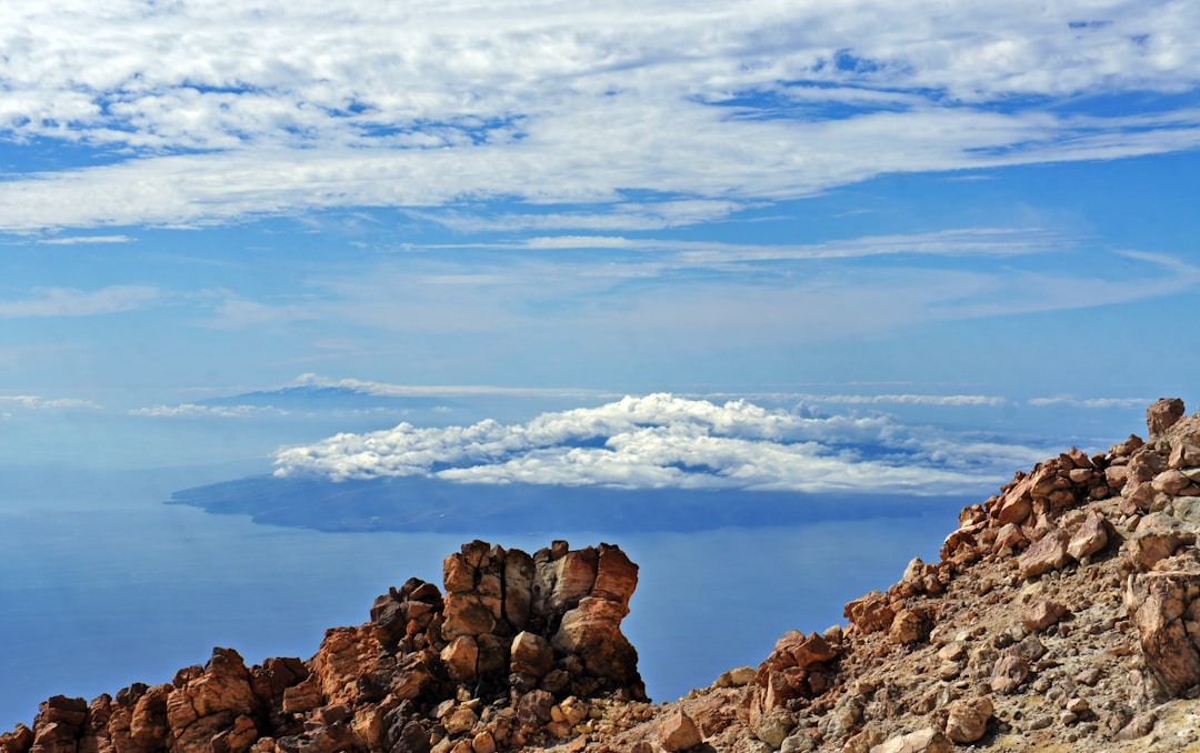 a view of a rocky mountain with clouds in the background